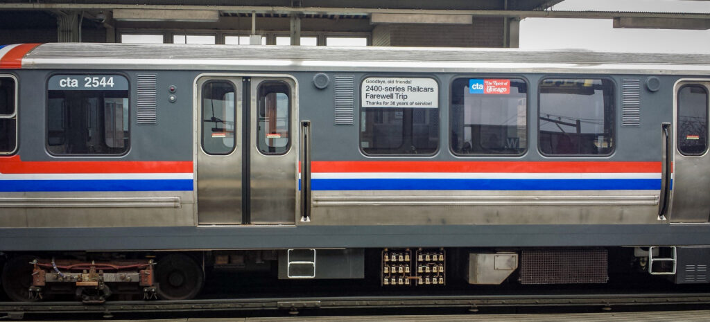 Two train cars are in a train station. 